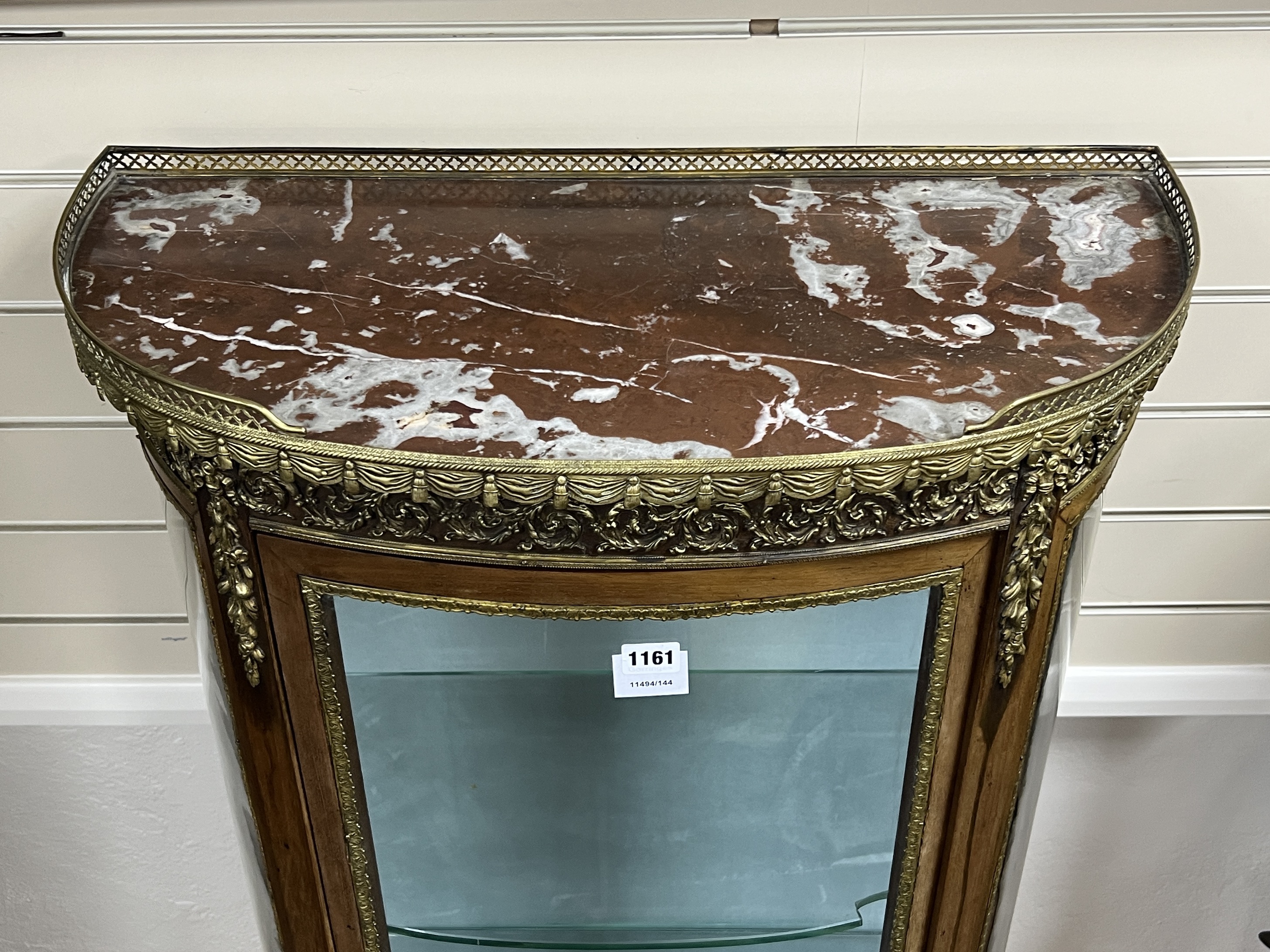 A French gilt metal mounted marble topped bow front vitrine, width 66cm, depth 32cm, height 140cm